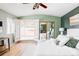Bright main bedroom with hardwood floors, white linens, and french doors leading to an outdoor deck at 4215 W Byron Pl, Denver, CO 80212