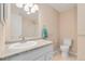 Well-lit bathroom featuring a granite countertop, white vanity, toilet, and a shower with glass doors at 7276 W 83Rd Way, Arvada, CO 80003