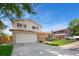 Charming two-story home featuring a lush lawn, brick accents, and an attached two car garage at 7276 W 83Rd Way, Arvada, CO 80003