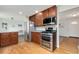 Well-lit kitchen with stainless steel appliances, including a double oven, and cherry wood cabinets at 7276 W 83Rd Way, Arvada, CO 80003