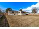 Backyard with a house addition, a patio, green grass and partial fence and treeline at 7720 Kendall St, Arvada, CO 80003