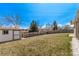 Backyard with a shed, green grass, and tall wooden fence at 7720 Kendall St, Arvada, CO 80003