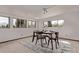 Bright dining area features modern wood table set and three large windows at 7720 Kendall St, Arvada, CO 80003