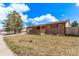 Brick house with covered front porch and well-maintained lawn and mature trees at 7720 Kendall St, Arvada, CO 80003