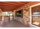 The covered front porch of this brick home features a classic wooden design and detailed front door at 7720 Kendall St, Arvada, CO 80003