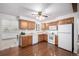 Bright kitchen with wood cabinets and modern white appliances, hardwood floors at 7720 Kendall St, Arvada, CO 80003