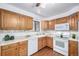 Charming kitchen featuring oak cabinets, white appliances, and sleek countertops at 7720 Kendall St, Arvada, CO 80003