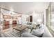Open living room with hardwood floors and cozy seating, flowing into the kitchen area at 7720 Kendall St, Arvada, CO 80003