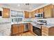 Modern kitchen featuring stainless steel appliances, wood cabinets, granite countertops, and lots of natural light at 24285 E Wagon Trail Ave, Aurora, CO 80016