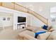Bright and airy living room with a view of the staircase, a large TV, and comfortable sectional sofa at 24285 E Wagon Trail Ave, Aurora, CO 80016