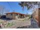 Wide backyard view showcasing patio, house, gravel landscaping, and wooden fence at 8221 Ralph Ln, Denver, CO 80221