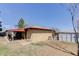 Backyard with brick house, a shed, a covered patio, and minimal landscaping at 8221 Ralph Ln, Denver, CO 80221