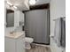 Basement bathroom featuring modern vanity, a mirrored medicine cabinet and shower with a grey curtain at 8221 Ralph Ln, Denver, CO 80221