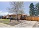 Charming single-story home featuring a red-bricked facade, an attached one-car garage, and wood fence at 8221 Ralph Ln, Denver, CO 80221