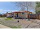 Charming single-story brick home featuring a well-maintained front yard and mature tree at 8221 Ralph Ln, Denver, CO 80221