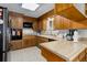 Traditional kitchen with wooden cabinetry, tile backsplash, and a view into a window for lots of natural light at 8221 Ralph Ln, Denver, CO 80221