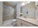 Modern bathroom with a glass-enclosed shower, neutral tile, and a vanity with a sleek countertop at 315 Painted Horse Way, Erie, CO 80516