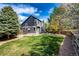Well-maintained backyard with lush green lawn, mature trees, a nice stone patio, and a privacy fence at 18572 E Tanforan Pl, Aurora, CO 80015