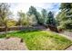 Private backyard featuring a well-manicured lawn, mature trees, garden and wood fencing at 18572 E Tanforan Pl, Aurora, CO 80015