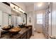 Bathroom featuring double sinks with bronze vessel bowls and black marble countertops at 18572 E Tanforan Pl, Aurora, CO 80015