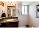 Stylish half-bathroom with granite countertop and elegant mirror at 18572 E Tanforan Pl, Aurora, CO 80015