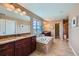 Luxurious main bathroom featuring dual vanities, a soaking tub, granite countertops, and decorative mirrors at 22197 E Stroll Ave, Parker, CO 80138