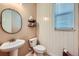 Cozy powder room features wood paneling, modern fixtures, and a pedestal sink at 22197 E Stroll Ave, Parker, CO 80138