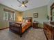 Cozy bedroom with ceiling fan, natural light, and a wooden sleigh bed, creating a warm, inviting space at 28592 Hummingbird Hill Rd, Conifer, CO 80433