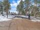 Gated driveway leading up to a charming front exterior with attached three-car garage and well-manicured lawn at 28592 Hummingbird Hill Rd, Conifer, CO 80433