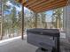 Back patio showcasing a hot tub with steps, offering a serene space to unwind and enjoy the natural surroundings at 28592 Hummingbird Hill Rd, Conifer, CO 80433