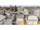 Aerial view showcases the gray townhomes with snow-covered roofs, garages, and driveways in the winter at 1530 Terry St, Longmont, CO 80501