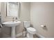 Cozy powder room featuring a modern pedestal sink, a toilet, and decorative fixtures at 1530 Terry St, Longmont, CO 80501