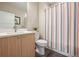 Bathroom featuring a modern vanity, toilet, and shower with stylish striped curtain at 1530 Terry St, Longmont, CO 80501
