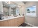 Elegant bathroom with double vanity, quartz countertop, framed mirror, stylish lighting, and walk-in shower at 1530 Terry St, Longmont, CO 80501