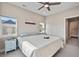 Well-lit bedroom with a ceiling fan, two windows with neighborhood views, and neutral tones throughout at 1530 Terry St, Longmont, CO 80501
