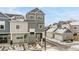 Modern townhome with a gray and light-gray exterior, green door, and a well-maintained front yard in winter at 1530 Terry St, Longmont, CO 80501