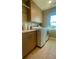 Bright laundry room with modern washer and dryer, upper cabinets, and a window for natural light at 1530 Terry St, Longmont, CO 80501