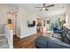 Open-concept living room with hardwood floors, a ceiling fan, and seamless flow into the kitchen and dining area at 1530 Terry St, Longmont, CO 80501