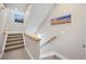 Carpeted staircase with modern wood railing is decorated with stylish wall art and recessed lighting at 1530 Terry St, Longmont, CO 80501