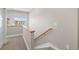 Carpeted staircase with wood railing leads to the upper level, lit by natural light from nearby window at 1530 Terry St, Longmont, CO 80501