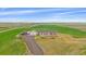 Aerial view of a tan home with red shutters surrounded by green and brown fields at 14551 N Harback Rd, Keenesburg, CO 80643