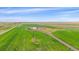 An aerial view of a rural property featuring green fields and a long driveway at 14551 N Harback Rd, Keenesburg, CO 80643