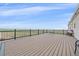 Spacious back deck with black railings overlooking open field under a clear blue sky at 14551 N Harback Rd, Keenesburg, CO 80643