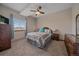 Comfortable bedroom with ceiling fan, large window with outside views, and neutral-toned carpet at 14551 N Harback Rd, Keenesburg, CO 80643