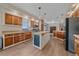 Bright kitchen with wooden cabinets, stainless steel refrigerator, and a center island for a modern, functional cooking space at 14551 N Harback Rd, Keenesburg, CO 80643