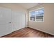 Bedroom with hardwood floors, a large window, and a closet with sliding doors at 152 Ambrose St, Erie, CO 80516