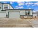 Exterior view of a townhome featuring a modern garage door and landscaped gravel at 152 Ambrose St, Erie, CO 80516