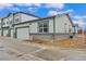 Exterior shot of townhome with a modern garage door and stone accents near the base at 152 Ambrose St, Erie, CO 80516