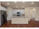 Bright kitchen featuring white cabinets, granite countertops, stainless steel appliances, and hardwood floors at 152 Ambrose St, Erie, CO 80516