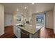 Modern kitchen island with granite countertop, stainless steel dishwasher, and view to the living room at 152 Ambrose St, Erie, CO 80516